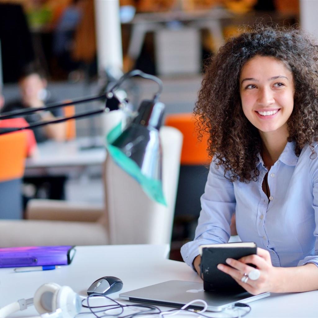 Eine junge Bürokauffrau sitzt an ihrem Arbeitsplatz 