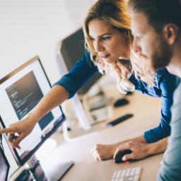 2 Fachinformatiker vor mehreren Bildschirmen 